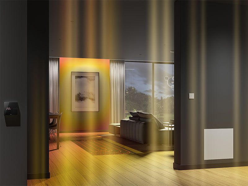 Ein gemütliches Wohnzimmer mit einer sichtbaren Fußbodenheizung und einem Thermometer an der Wand.